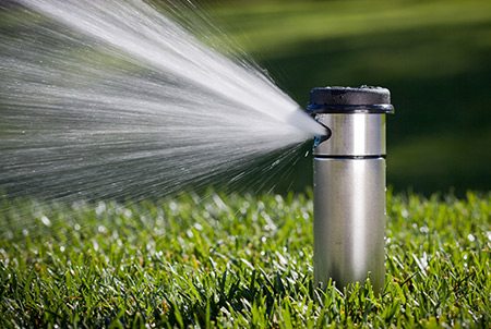 Oahu Sprinkler Services Image of a sprinkler watering a lawn
